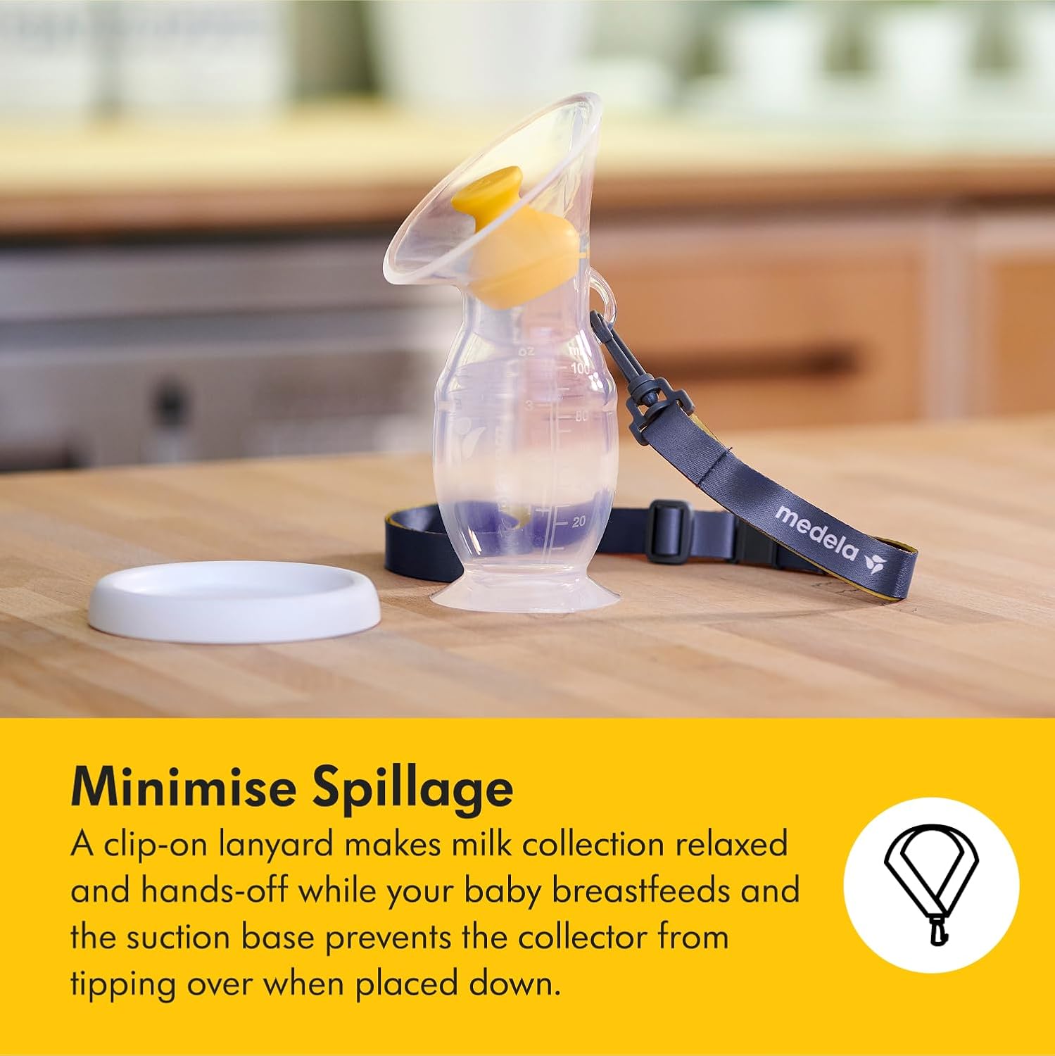 Medela silicone breast milk collector with yellow valve and navy lanyard strap