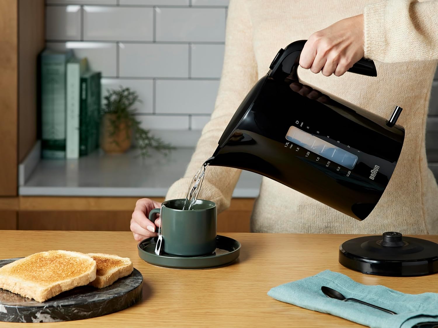 Braun black rapid boil kettle 1.7 litre with water level indicator pouring hot water into cup