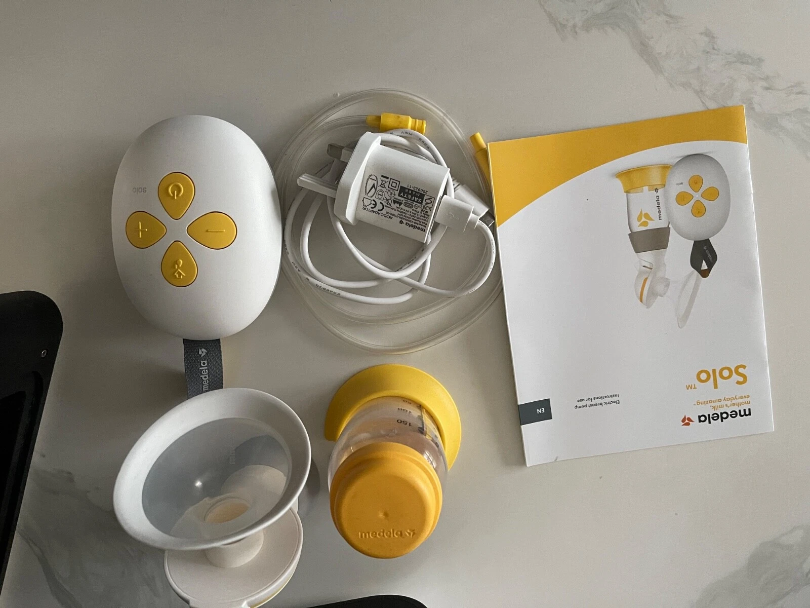 Medela Swing Flex single electric breast pump with white and yellow components, tubing, and accessories