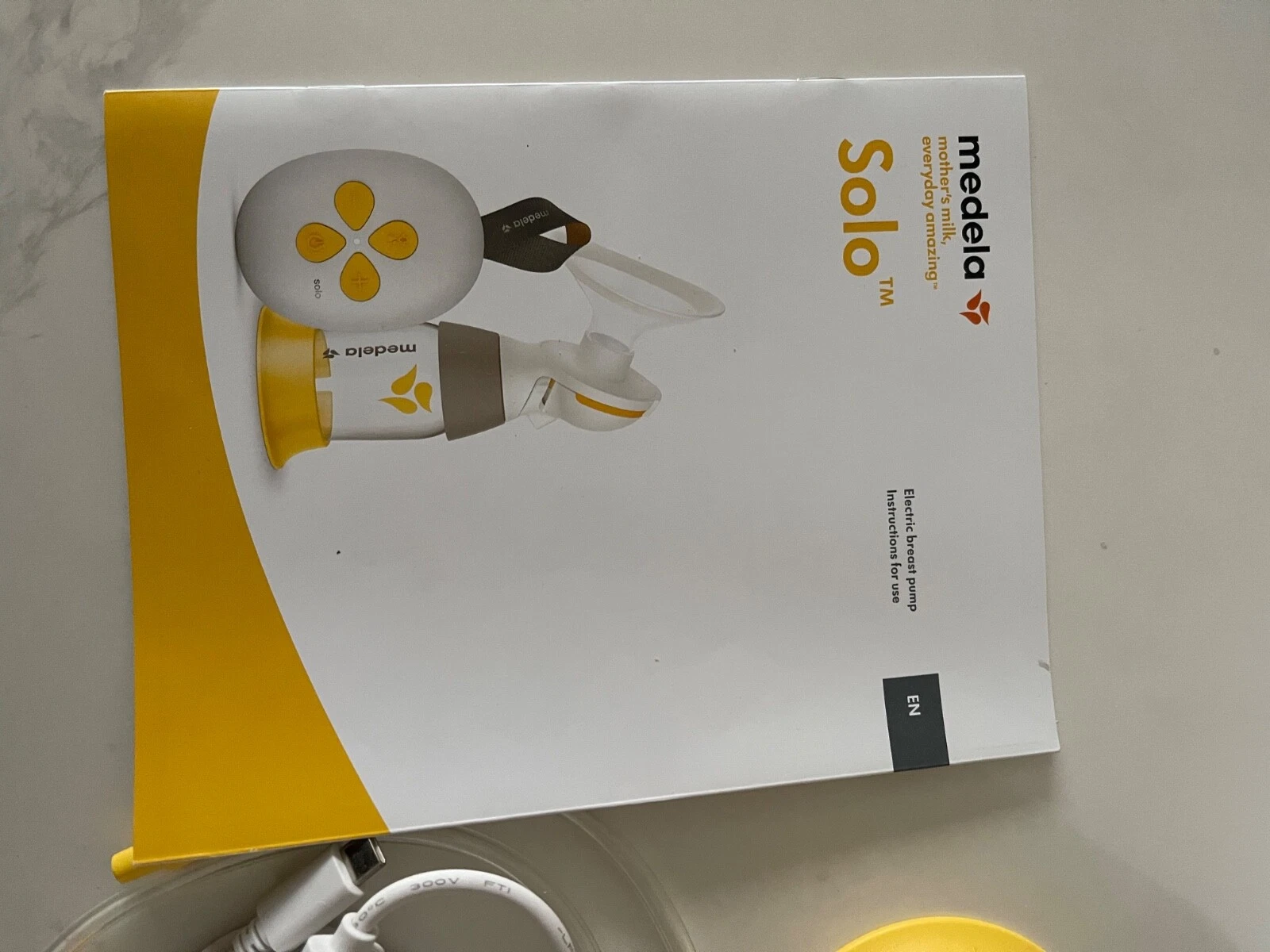 Medela Swing Flex single electric breast pump with yellow accents and collection bottle
