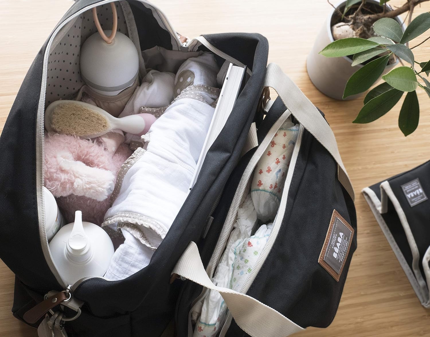 Béaba Geneva II navy blue changing bag open with baby items and accessories inside