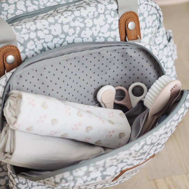 Béaba Geneva II cherry blossom changing bag 23L with brown handles open showing interior storage compartments
