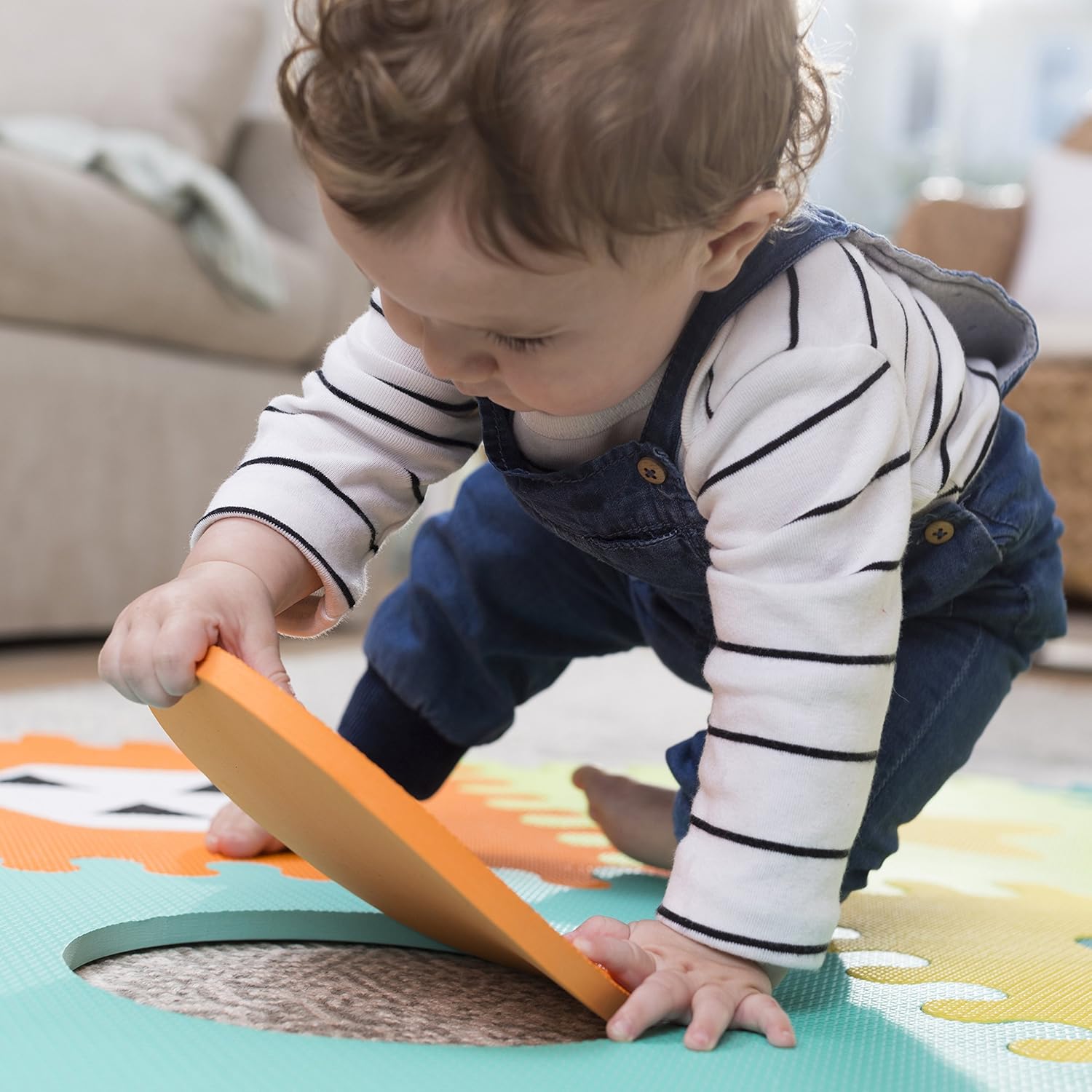 Infantino soft foam puzzle mat with colourful interlocking pieces in orange, turquoise and yellow