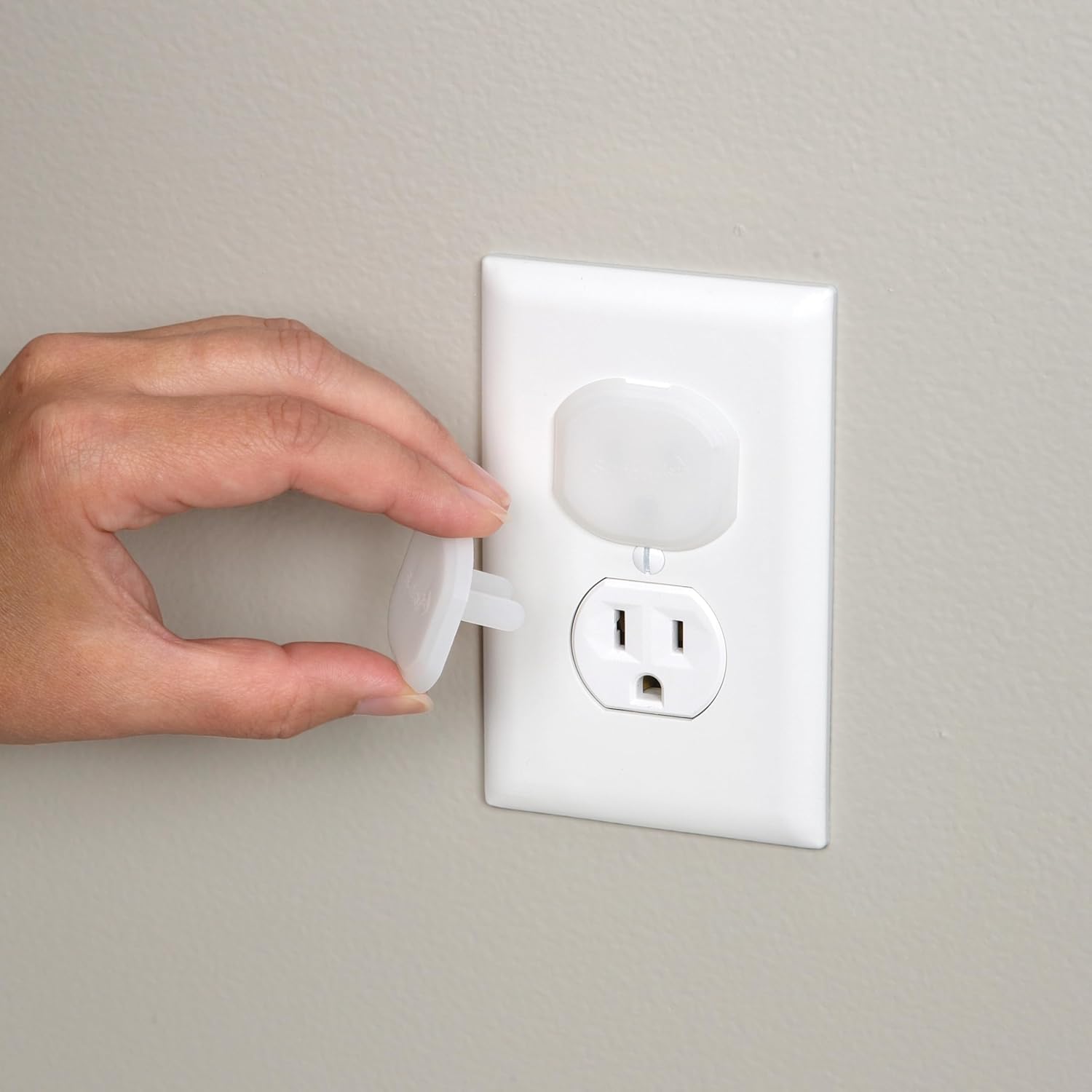 Safety 1st white socket insert being inserted into electrical outlet