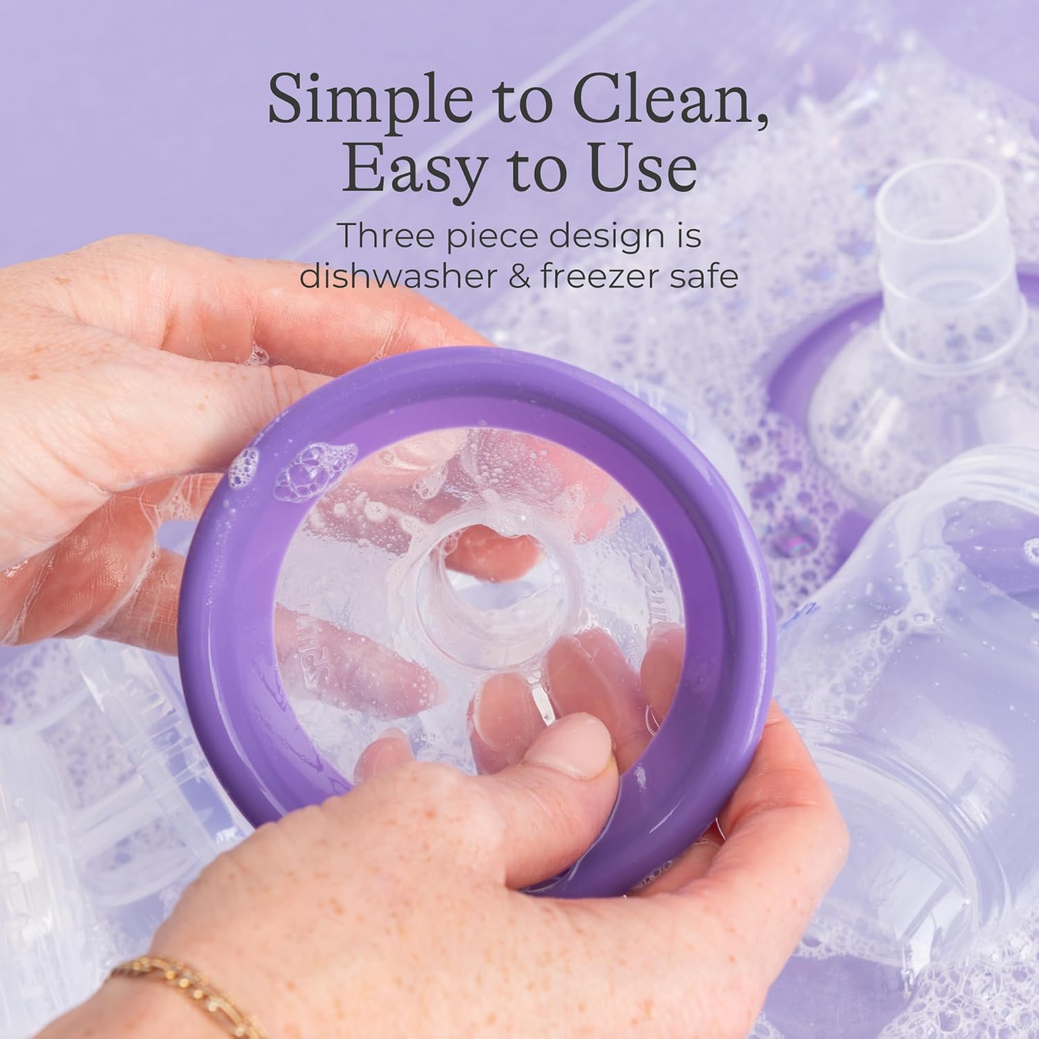 Lansinoh 2-in-1 electric breast pump with purple flange held in hand, dishwasher safe