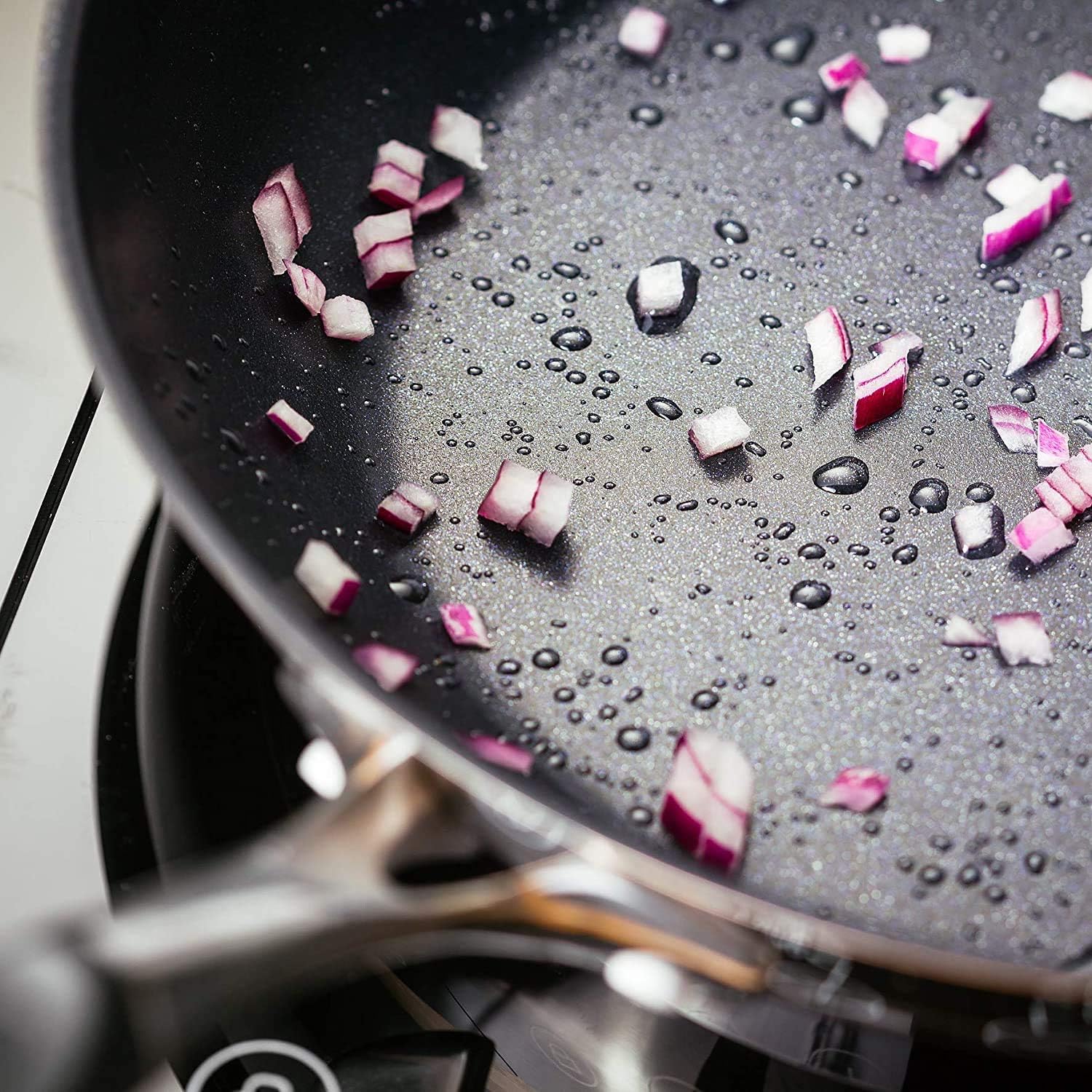 Stellar James Martin 24cm non-stick saute pan with diced onions and water beads