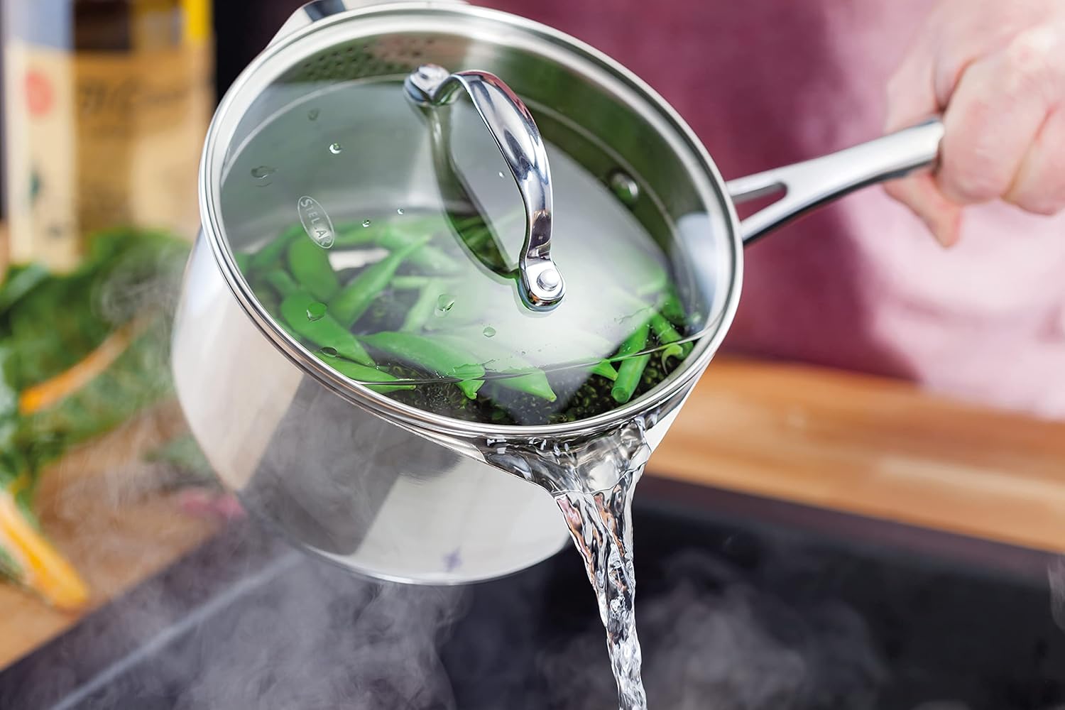 Stellar stainless steel saucepan with glass lid pouring water over broccoli